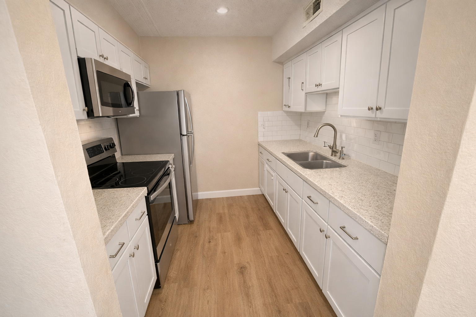 Renovated galley kitchen with white shaker cabinets